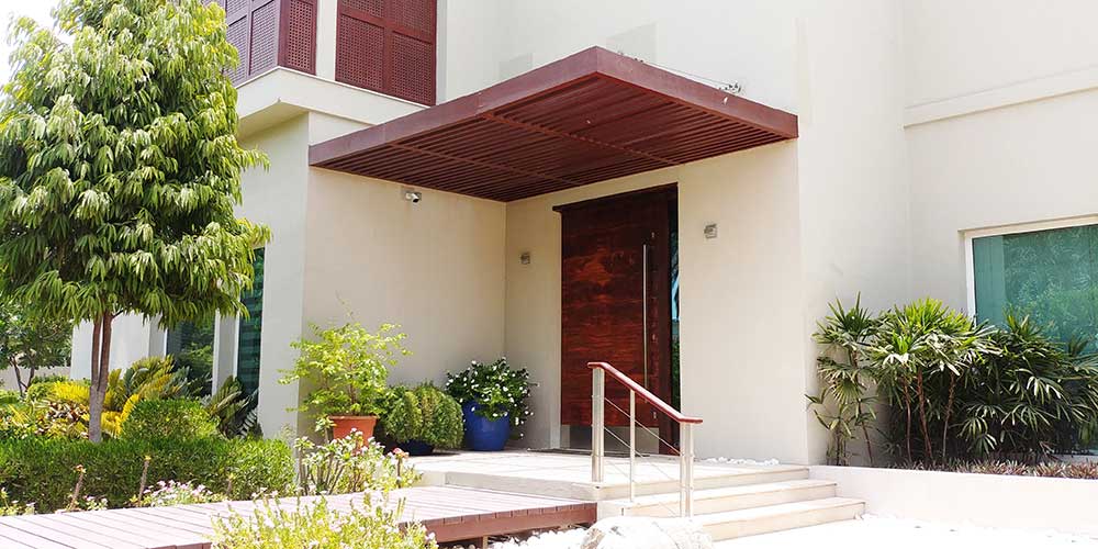 Wooden pergola shades the entrance porche at the Samina Ahmed Villa in Emirates Hills by RTAE